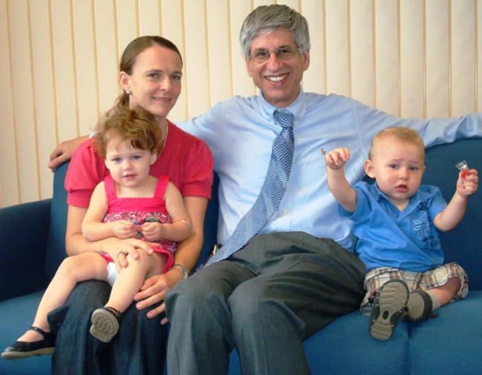 A man and woman with two small children smiling for camera.